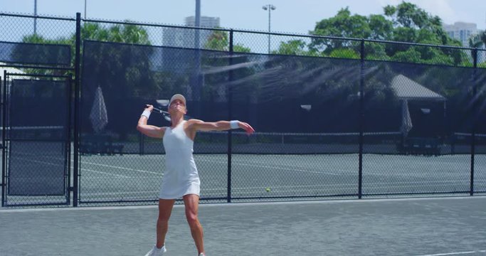 Girl hitting tennis ball backhand