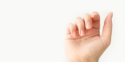 Obraz premium Close up woman hand with nails form of soft square holds something in fingers. Female keeps virtual object. Nail care at home. Copy space.