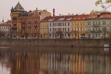 Fototapeta na wymiar view of the river and reflections in it. Old Prague architecture by the river Vltava. In the Czech Republic
