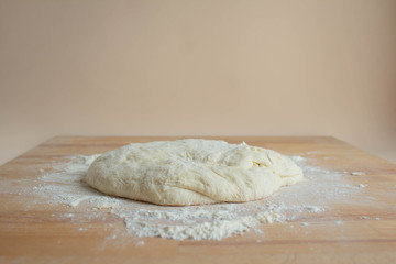 Preparing dough for homemade pastry bread, pizza, pasta on the background of a wooden table.