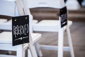 black reserved sign on chair at wedding ceremony