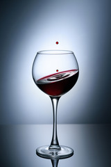 A glass of red wine against a bright light