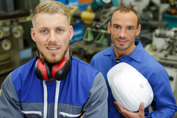 portrait of two engineers in a factory