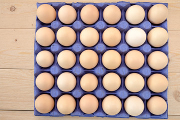 eggs in a box  on wooden background flat lay 