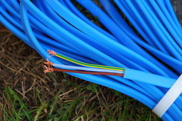 A blue submersible cable lies on the ground. Electrical cable with copper conductors with...