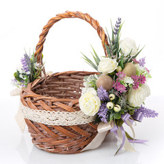 Fototapeta na wymiar Stylish brown wicker Easter basket with very beautiful Provence decor. Decorated with many different flowers, ribbons and lace.