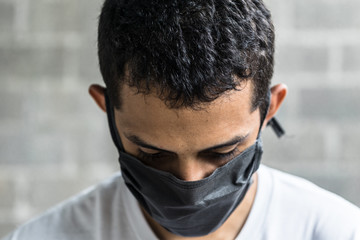 Hombre joven con la cabeza hacia abajo mostrando tristeza y depresión.