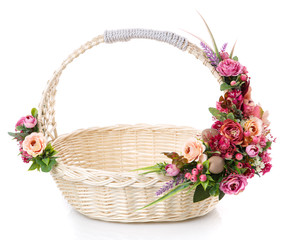Fototapeta na wymiar Round basket of natural vine with beautiful floral decoration on the handle. Floral arrangement in pink.