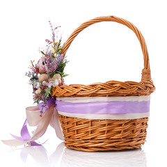Fototapeta na wymiar Stylish brown wicker Easter basket with very beautiful Provence decor. Decorated with many different flowers and ribbons.