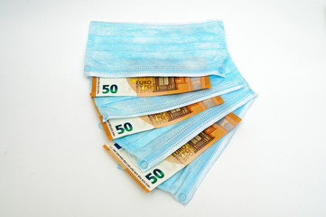 Euro banknotes between medical masks