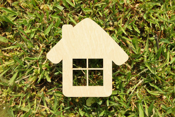 Small wooden house on green grass. Buying a property