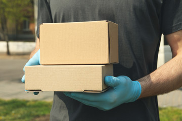 Delivery man in gloves holds blank boxes, space for text
