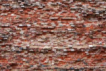 An old wall of weathered red brick