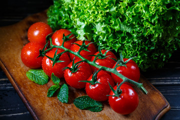 Tomatoes on the vine. Rustic wooden background. Healthy food.