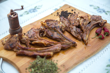 Azeri national antrikot kebab on a wooden board . Dry Satureja . Dried savory spice Satureja hortensis . Copper pepper dish . Antrikot kebabs .