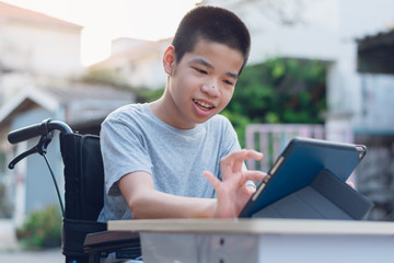 Disabled child on wheelchair happy time to use a tablet in the house, Study and Work at home for safety from covid 19, Life in the education age of special need kid, Happy disability boy concept. - Powered by Adobe