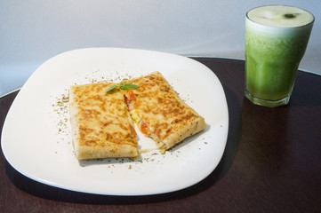 Cheese and ham crepe with tomato and oregano. Accompanied by a green juice (pineapple with mint)