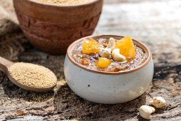 Delicious amaranth topped with cashew nuts. Healthy colorful gluten free food concept. Raw Organic Amaranth Grain in a Bowl witn wooden spoon. Rustic wooden background. healthy vegetarian Breakfast.