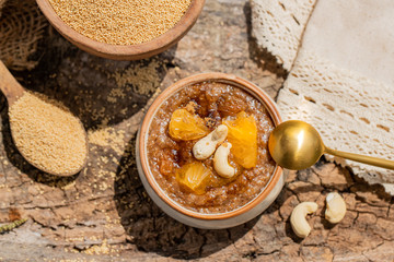 Delicious amaranth topped with cashew nuts. Healthy colorful gluten free food concept. Raw Organic Amaranth Grain in a Bowl witn wooden spoon. Rustic wooden background. healthy vegetarian Breakfast.