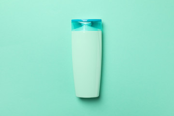 Blank bottle of shampoo on mint background, space for text