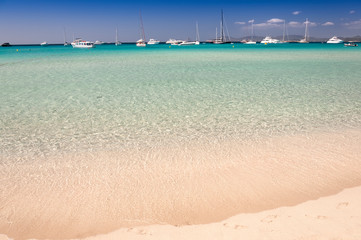 Fantastic panoramic view of Illetas beach, Formentera, Spain. Sailing ships and yachts at anchor near the beach