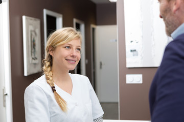 Obraz premium male patient with nurse at reception desk in hospital