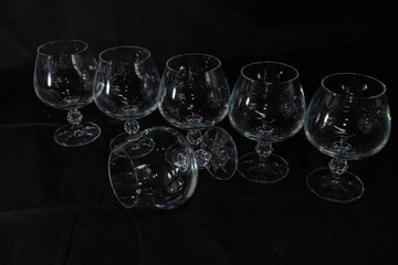 six clear crystal glasses on a dark background