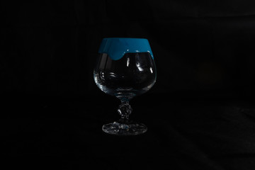 one crystal glass on a dark background with thick gouache