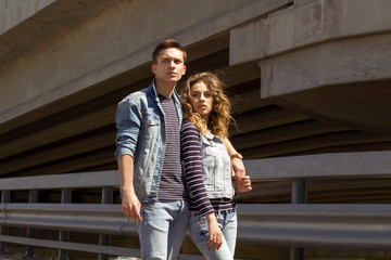 Two young people man and woman wearing jeans outdoors. Fashion concept with beautiful couple.