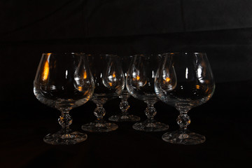 six clear crystal glasses on a dark background