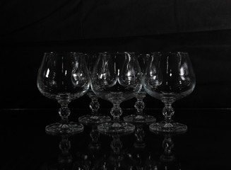 six clear crystal glasses on a dark background