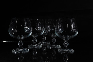six clear crystal glasses on a dark background