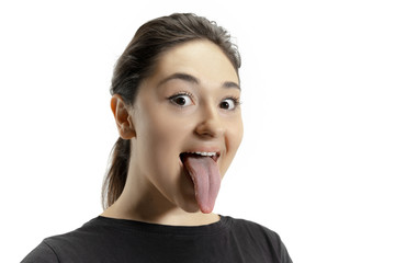 Smiling girl opening her mouth and showing the long big giant tongue isolated on white background....