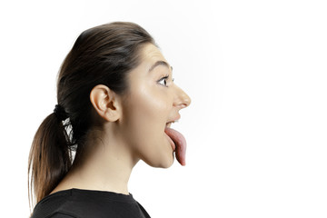 Smiling girl opening her mouth and showing the long big giant tongue isolated on white background. Looks shocked, attracted, wondered and astonished. Copyspace for ad. Human emotions, marketing. © master1305