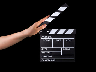 Human hand holding film clapper board isolated on black background