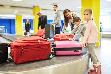 Passengers pick up their suitcases on the luggage belt
