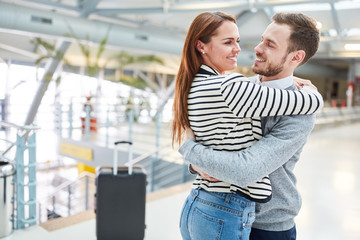 Happy couple hugs each other after the trip