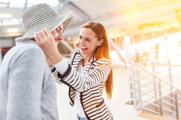 Couple at the airport having fun with hat on vacation