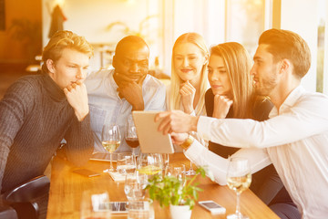 Group at meeting in restaurant with tablet computer
