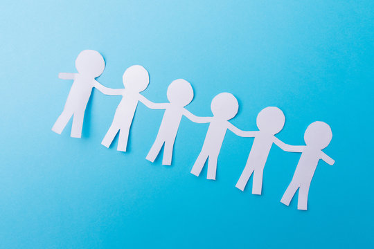 White Paper People Holding Hands. Blue Background