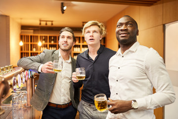 Friends watch football match in a pub