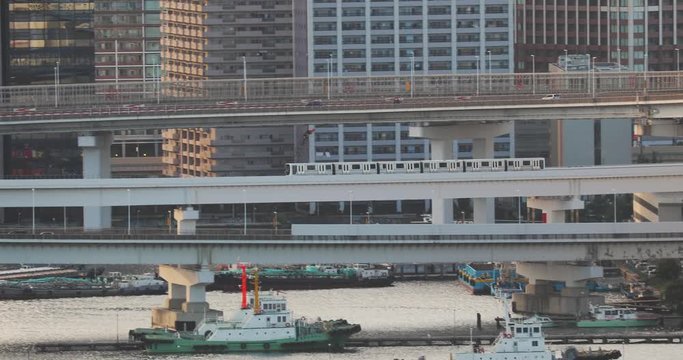 Traffic on ramps, railway and road ovepasses, train moving toa bridge in Tokyo, Japan