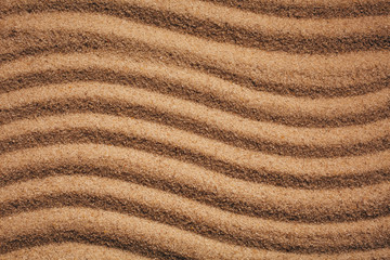 Summer sandy background or texture. Sandy waves near the sea.