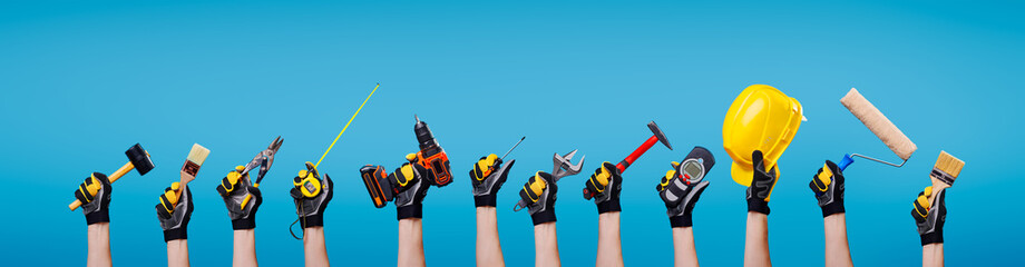 Workers hands with different tools on empty blue background - obrazy, fototapety, plakaty