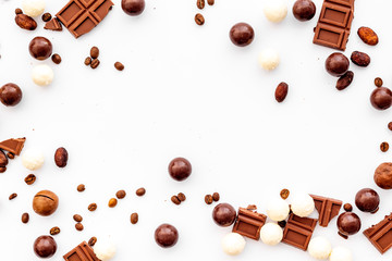 Candy background with chocolate on white table top view frame. Sweets desserts concept. Space for text