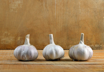 
beautiful garlic lies on a yellow wooden table