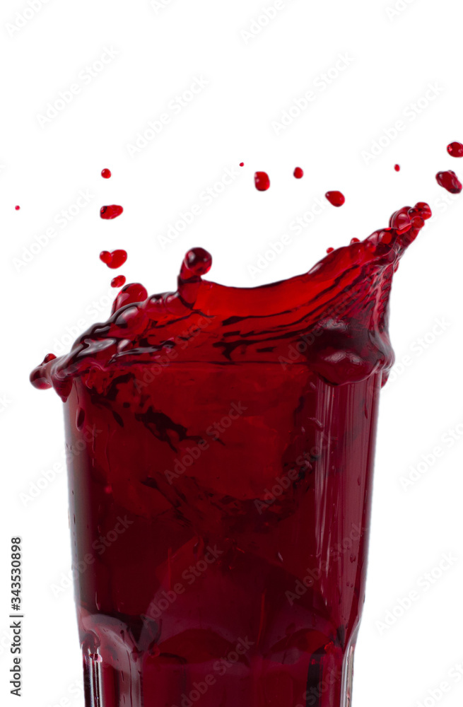 Wall mural beautiful splash, splashes of wine or juice in a glass, isolate on a white background