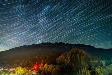 Star trails over the Plaiul Foii resort in Piatra Craiului mountains from Romania