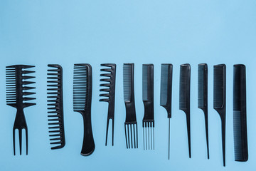 Equipo de peinado y corte de cabello como son peines, rasuradora y tijeras  acomodados sobre un fondo azul