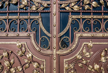 Forged and painted metal gate elements close-up as a background.